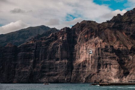 Rescue helicopter flying between the cliffs of Los Gigantes